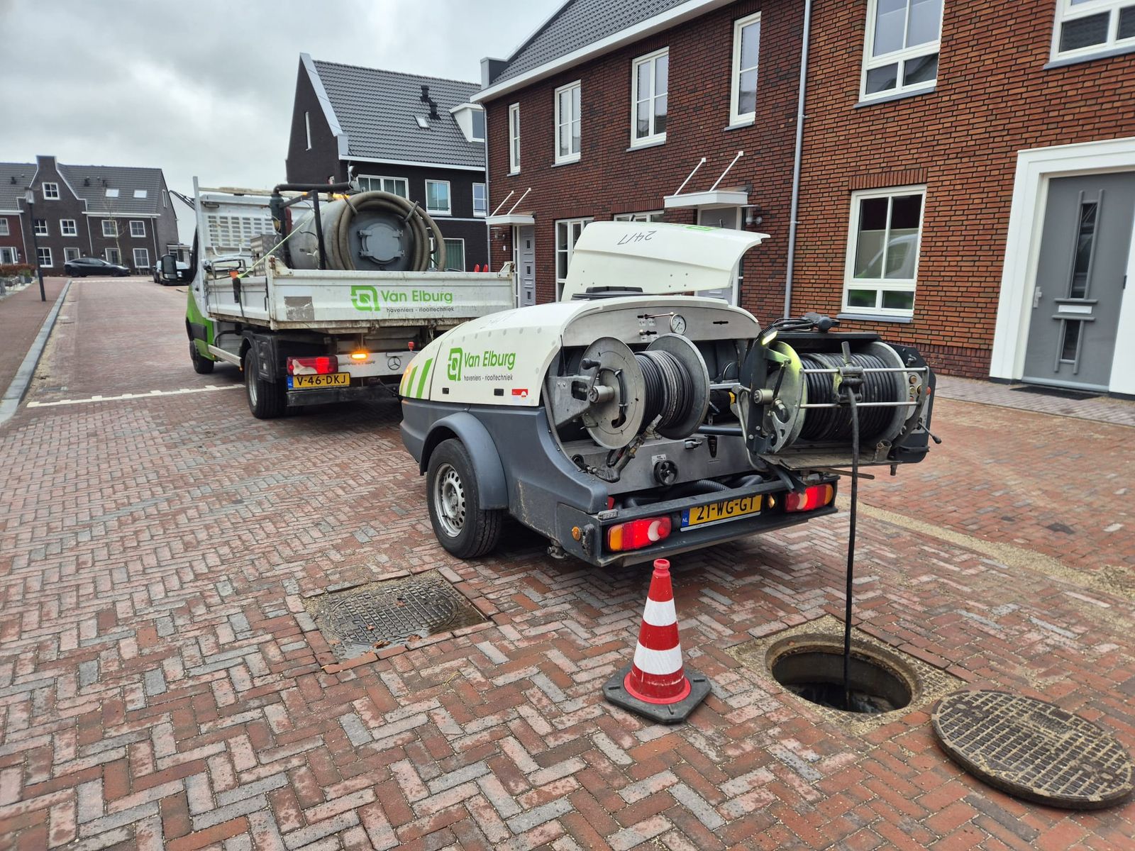 Rioolreinigingswagen van Van Elburg Riooltechniek bij een geopende put in de straat