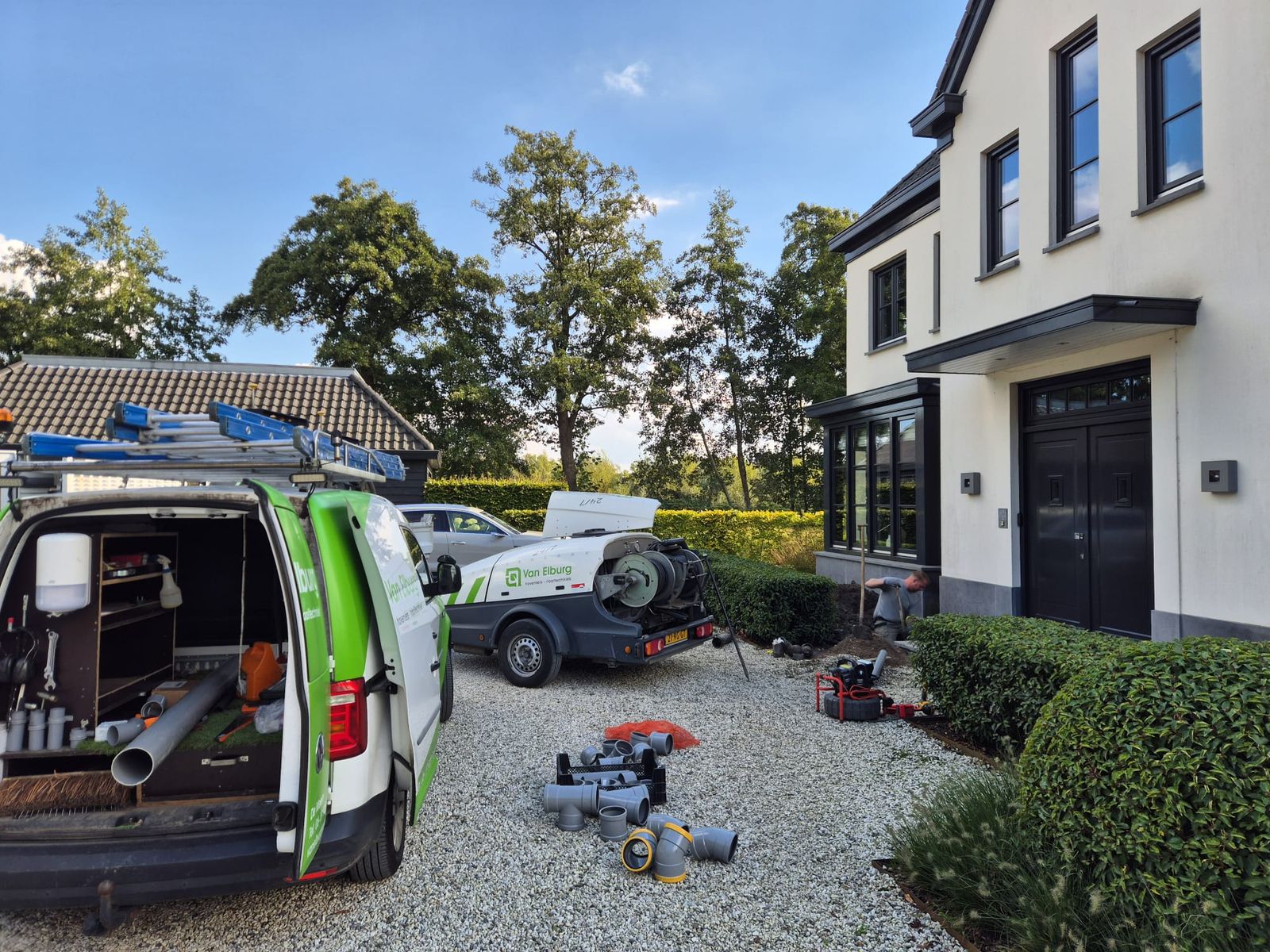 Bus en reinigingswagen van Van Elburg bij een woning in de regio Utrecht
